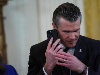 El secretario de Defensa de Estados Unidos, Pete Hegseth, al teléfono antes de entrar en rueda de prensa .