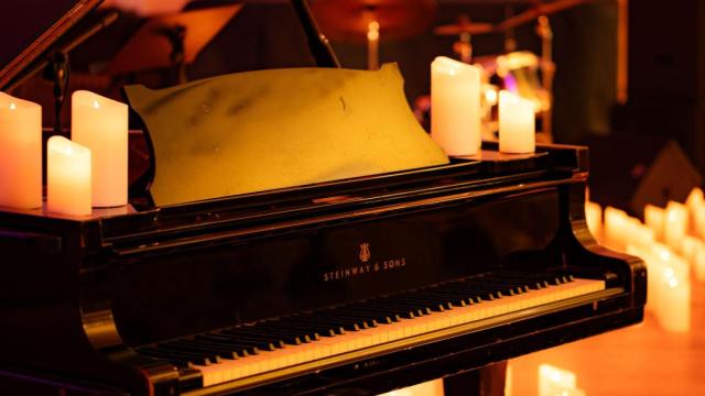 Un piano rodeado de velas