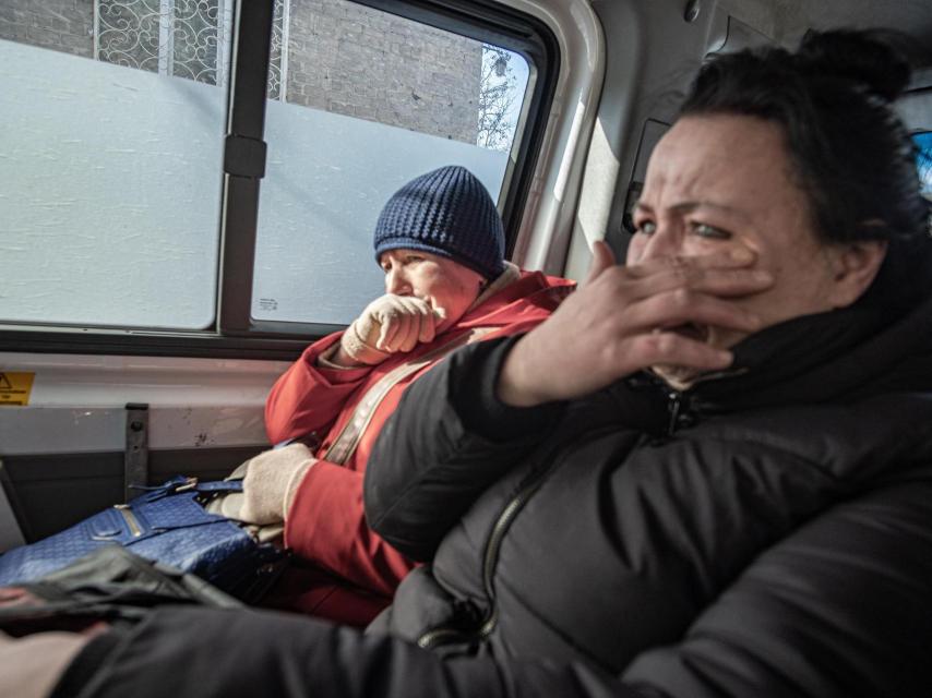 Dos mujeres lloran al abandonar su casa en Kostantínivka.