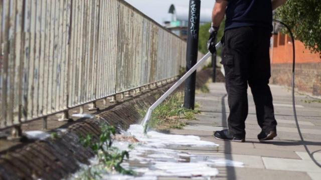 Una persona utilizando el dispositivo Foamstream para quitar las malas hierbas.