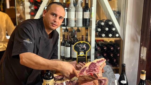 El cocinero Mohamed El-Hamdy posa con una de las chuletas que prepara en el restaurante La Tropical, de Los Alcázares (Murcia).