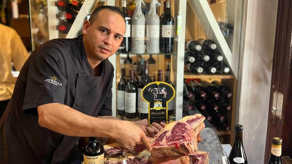 El cocinero Mohamed El-Hamdy posa con una de las chuletas que prepara en el restaurante La Tropical, de Los Alcázares (Murcia).