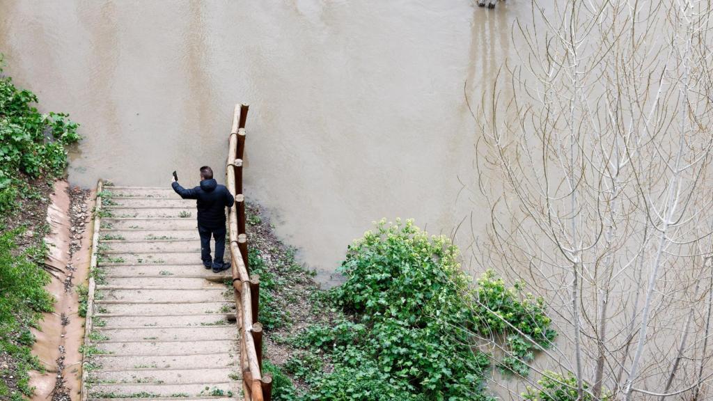 Un hombre hace fotos a la crecida del río Tajo en Toledo.