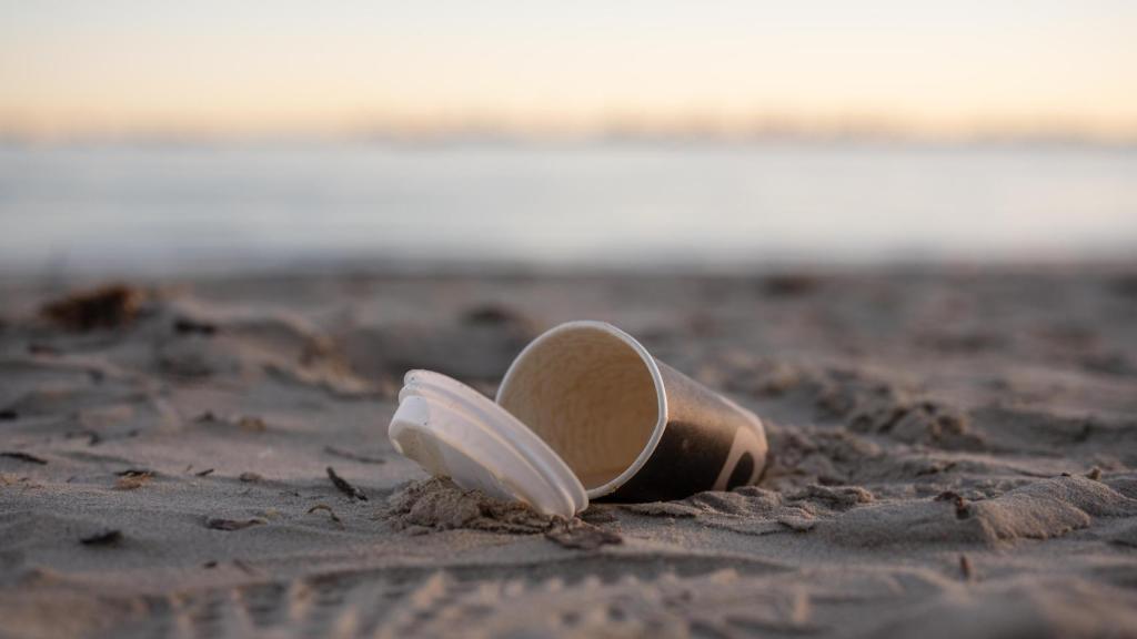 Un vaso de papel tirado en la playa, en una imagen de Shutterstock.