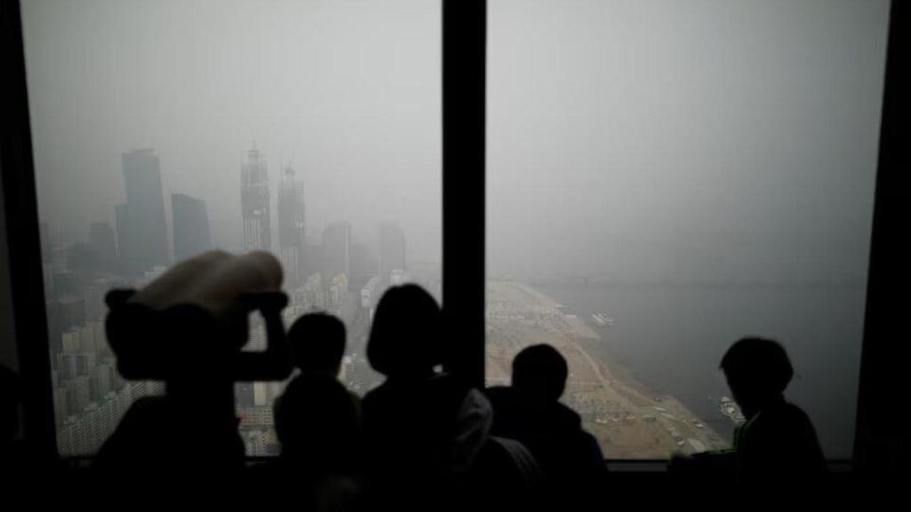 Unos niños observan la vista de Seúl cubierta por una densa niebla contaminante, en Seúl, Corea del Sur, el 15 de enero de 2019.