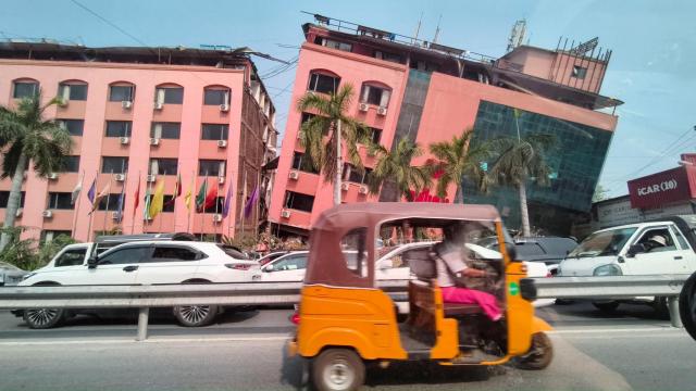 Automovilistas pasan junto a un edificio dañado después de que un fuerte terremoto azotara el centro de Myanmar, en Mandalay, Myanmar, el 28 de marzo de 2025.