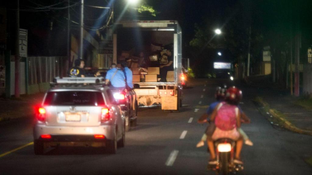 Un camión con varias cajas y documentos de La Prensa. Detrás va una patrulla policial y el coche conducido por Juan Lorenzo Holmann.