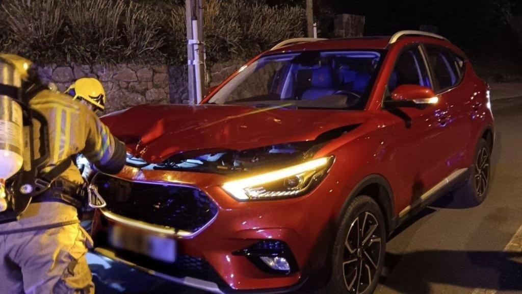 Los bomberos con uno de los coches dañados.