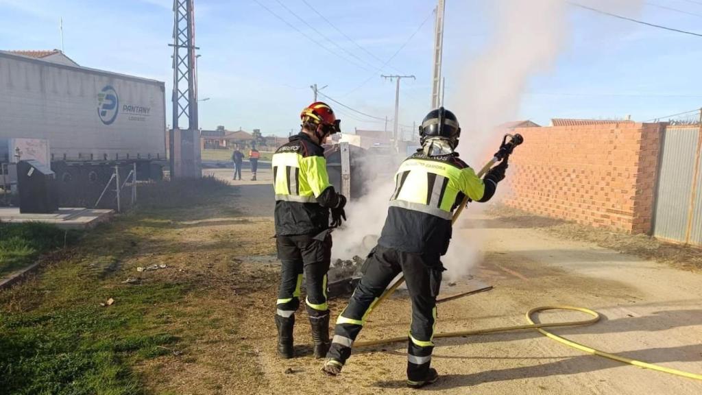 Los bomberos de la Diputación de Zamora apagando el contenedor incendiado, este sábado