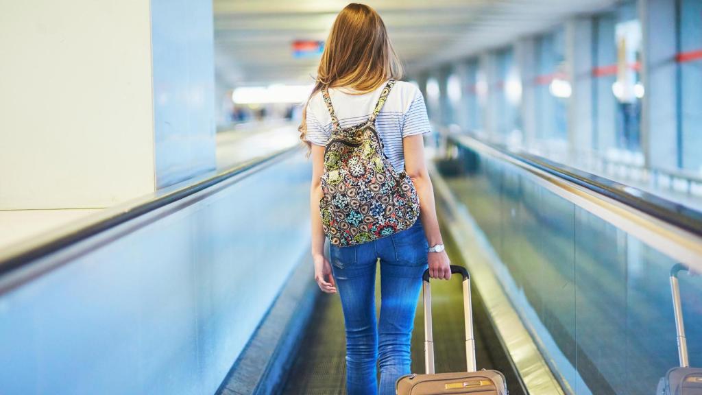 Una mujer en un aeropuerto, en una imagen de Shutterstock.