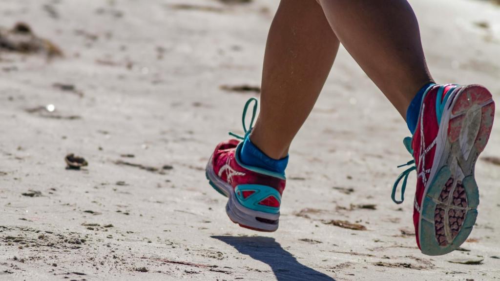 Una persona corriendo por la playa.