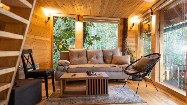 Interior de una casa de madera con amplios ventanales.