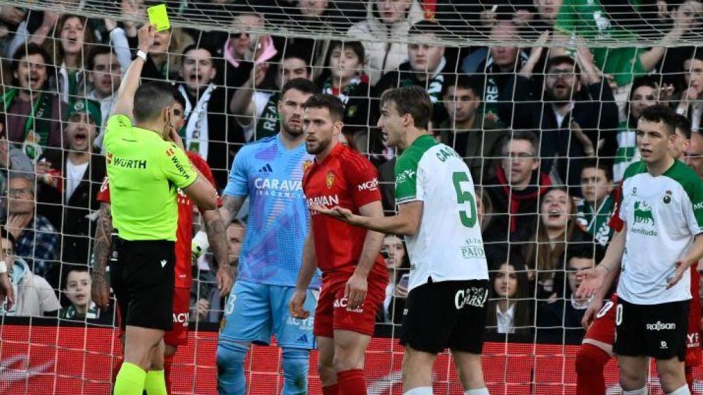 El colegiado enseña la amarilla a Iván Calero.