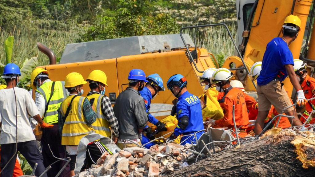 Rescatistas cargan el cuerpo de una víctima tras el terremoto en Birmania.