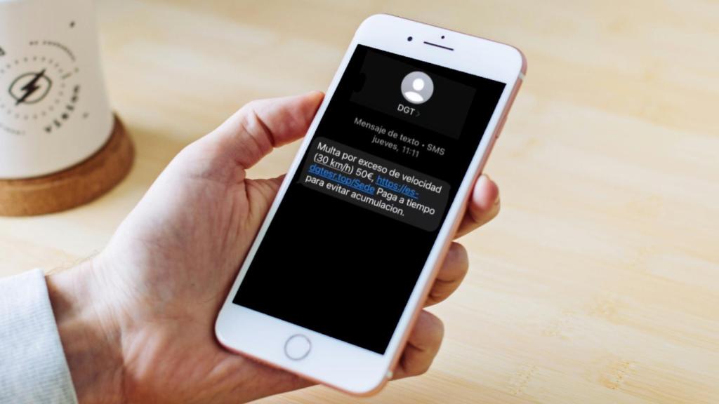 Fotomontaje de un móvil y el SMS que se hace pasar por la DGT.