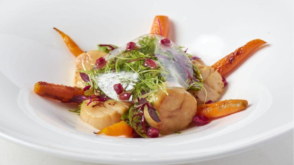 Vieira macerada en soja fermentada zanahoria asada y granada con brotes tiernos.