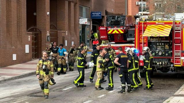 Los bomberos se consuelan entre ellos tras la muerte de dos compañeros en Alcorcón.