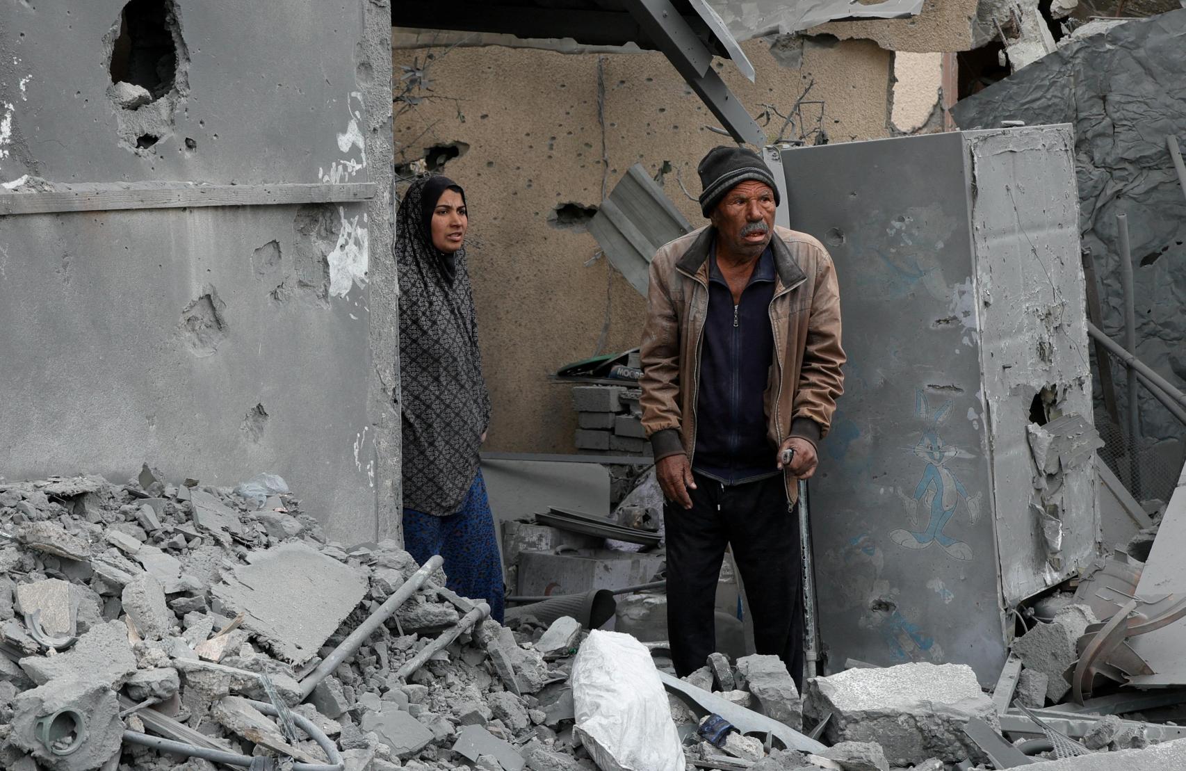 Dos palestinos contemplan los escombros de un edificio en Jan Yunis.