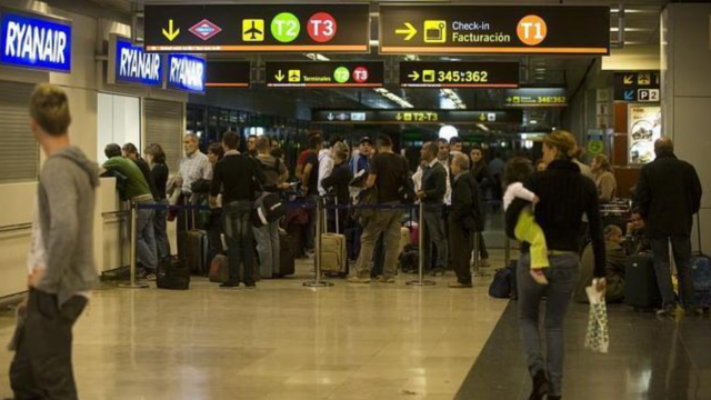 Personas esperando en un mostrador del aeropuerto de Barajas.