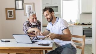 Un padre y su hijo revisan juntos unos documentos.