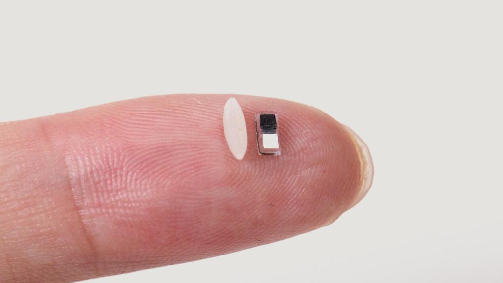 El diminuto marcapasos colocado junto a un grano de arroz en la yema del dedo.