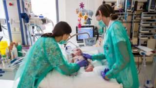 Dos enfermeras cuidando de un bebé en la UCI pediátrica del Hospital Sant Joan de Dèu de Barcelona.