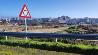 Señal de la rotonda de la Tercera Ronda que en el futuro dará acceso a la nueva zona residencial de Visma, al fondo en obras.