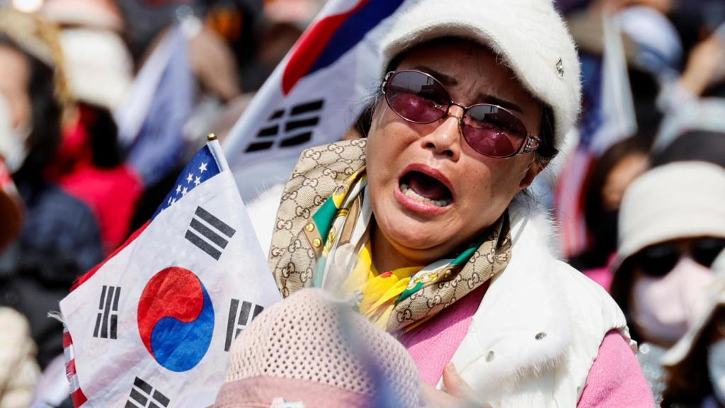 os manifestantes de extrema derecha reaccionan después de escuchar que el juicio político del presidente Yoon Suk Yeol fue aceptado, cerca de su residencia en Seúl