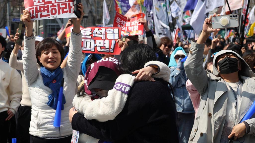 La gente celebra después de que se aceptara el juicio político del presidente Yoon Suk Yeol, cerca del Tribunal Constitucional de Seúl, Corea del Sur.