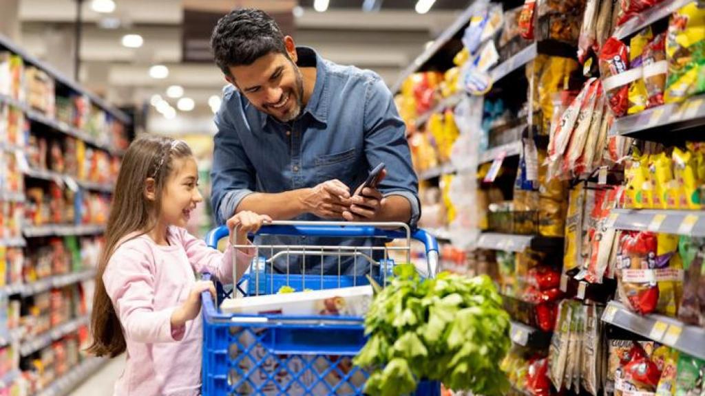 Imagen de archivo de un padre y su hija en el supermercado.