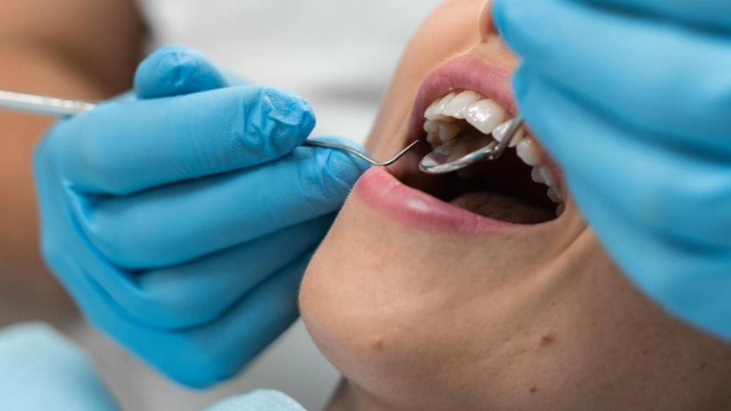 Un dentista atiende a un paciente en un consultorio.