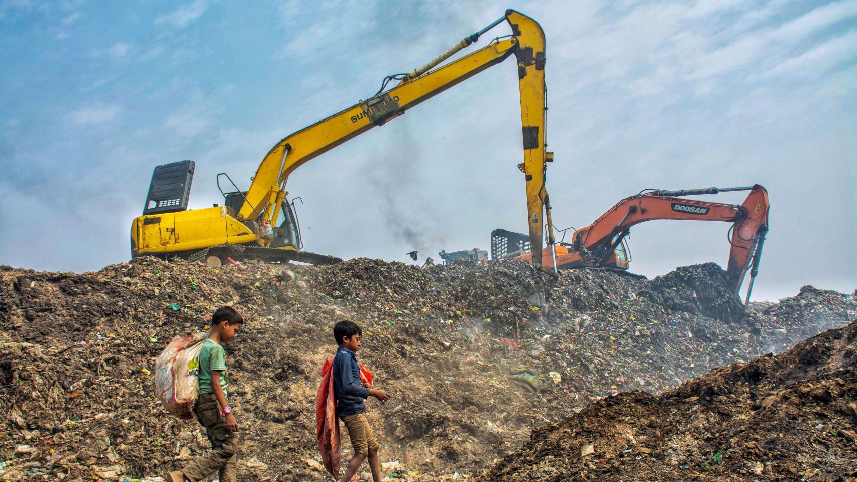 Dos niños rebuscando basura en un vertedero.
