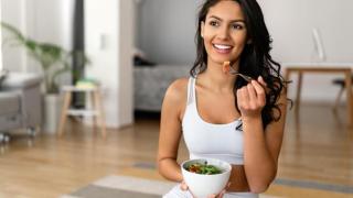 Mujer comiendo una ensalada después de hacer deporte.