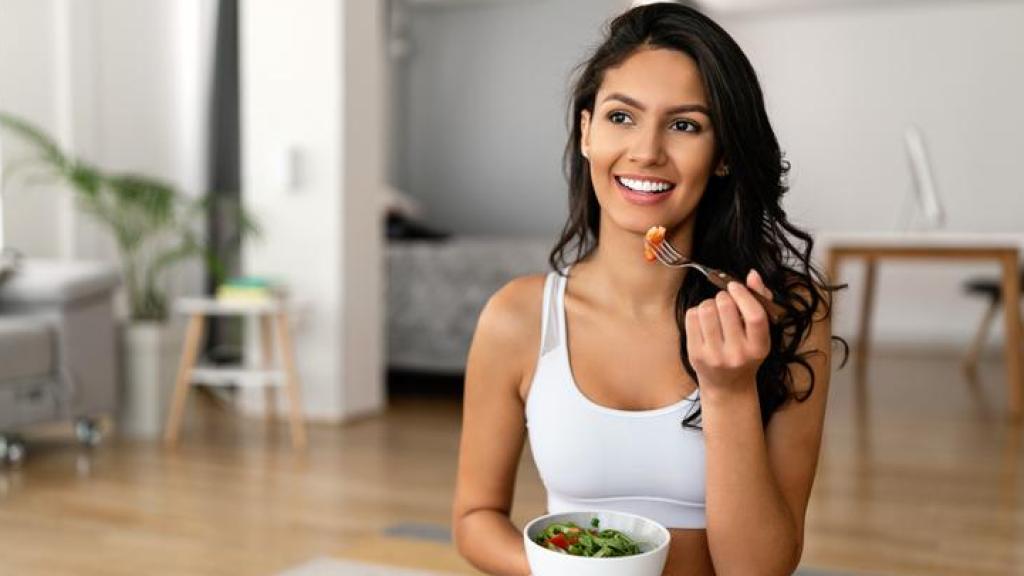 Mujer comiendo una ensalada después de hacer deporte.