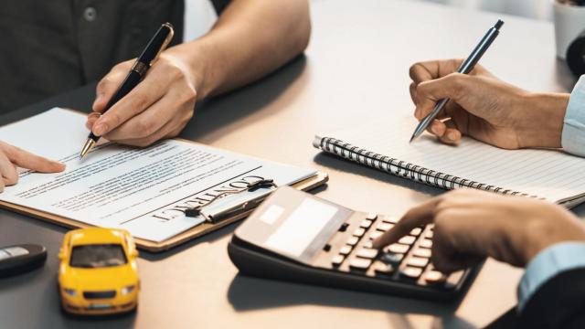 Una persona firmando la documentación para contratar un seguro de coche.