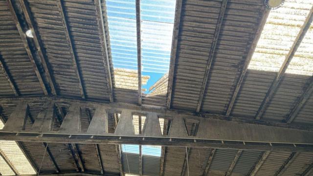 Hueco del techo de la nave por el que se ha precipitado el trabajador.