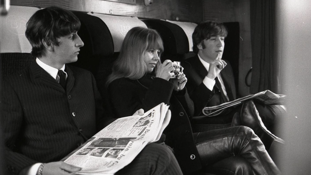 Astrid Kirchherr (con la cámara), Ringo Starr y John Lennon sentados en un tren durante el rodaje de 'A Hard Day's Night' en 1960.