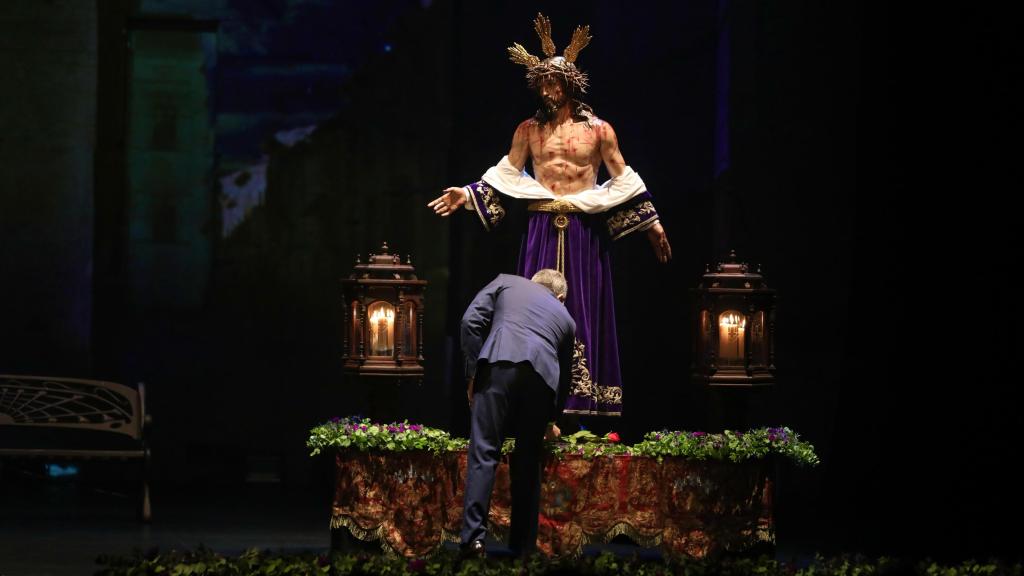 Julio López Revuelta, emocionado, entregando una rosa roja al Cristo Despojado