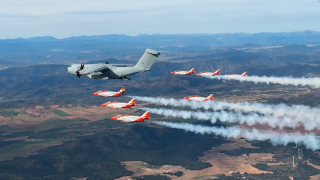 Patrulla Águila volando junto al A400M con la compuerta abierta