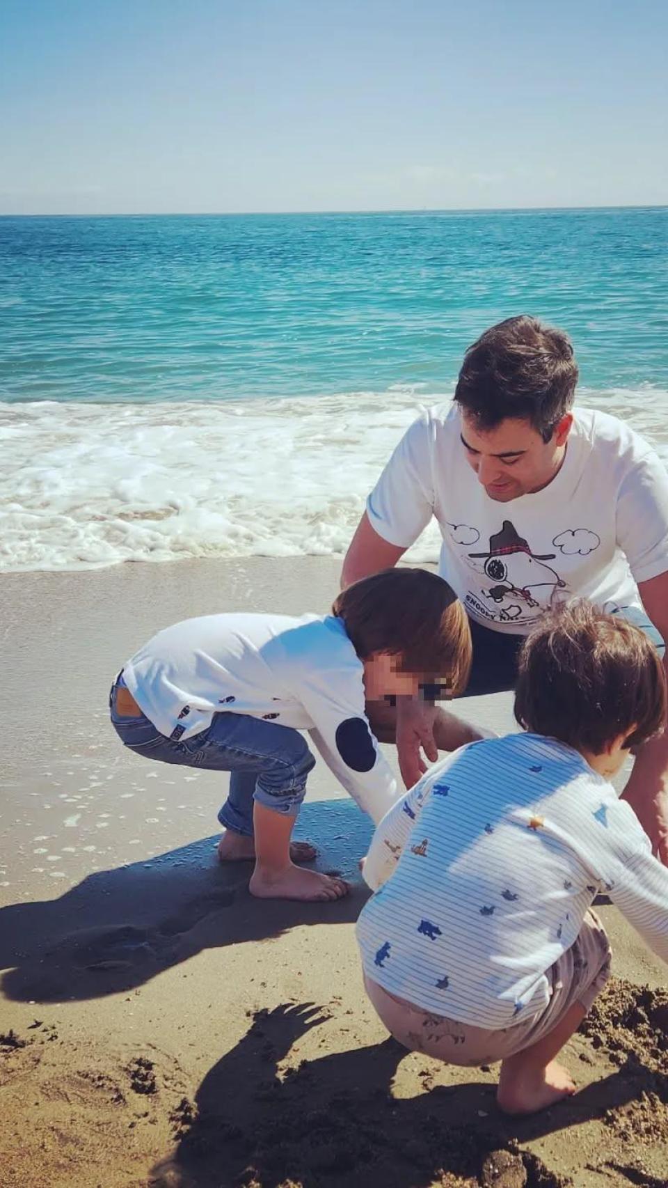 Álex Cruz con sus hijos, en la playa.