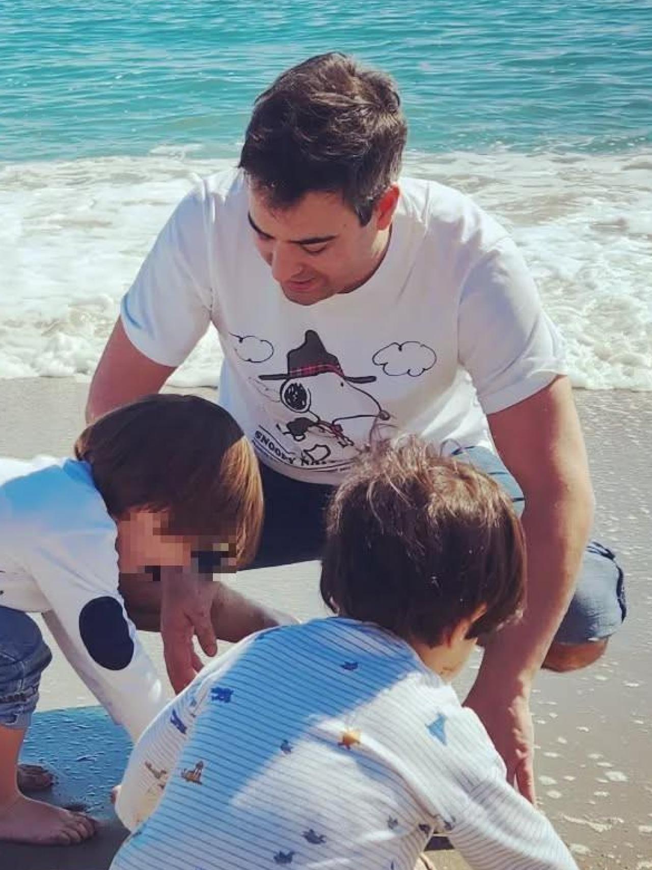 Álex Cruz junto a sus hijos, en la playa.