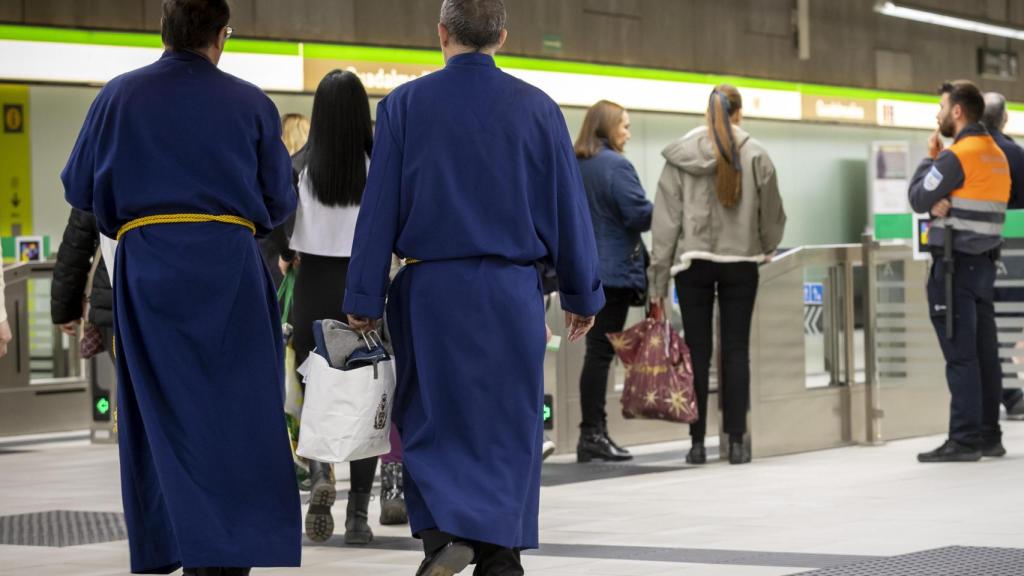 Dos cofrades, en una de las estaciones del Metro de Málaga.