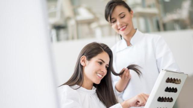 Mujer eligiendo tinte en la peluquería.