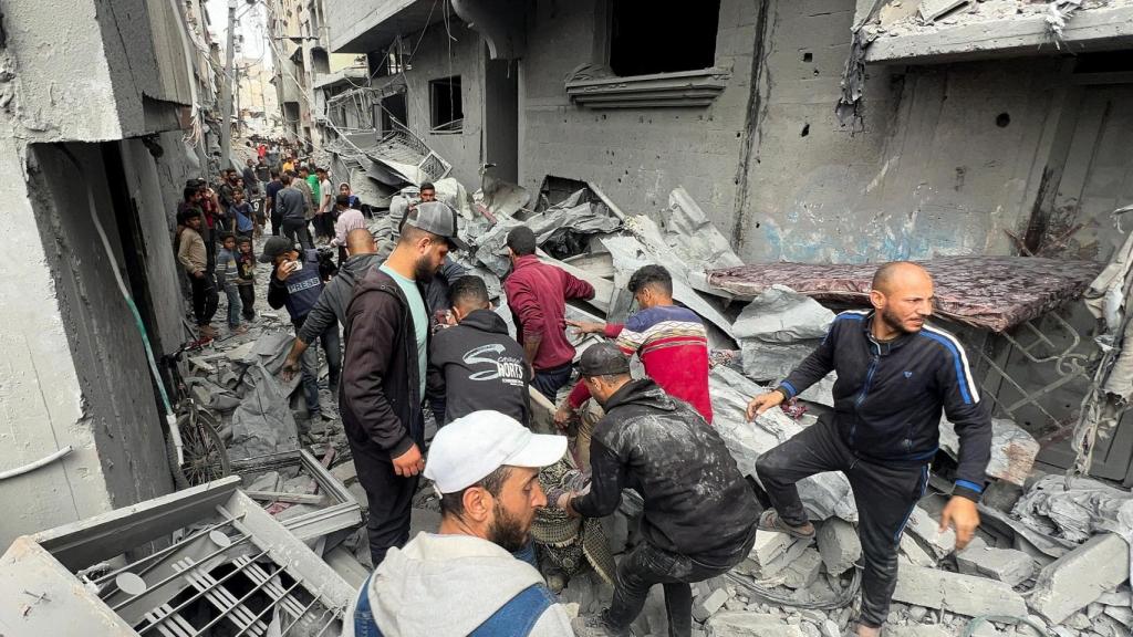 Palestinos cargan con un cuerpo recuperado de los escombros tras el ataque de Israel de este miércoles.