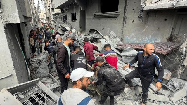 Palestinos cargan con un cuerpo recuperado de los escombros tras el ataque de Israel de este miércoles.