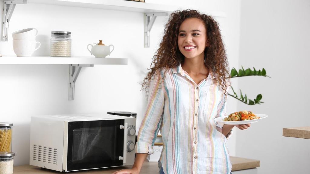 Una mujer con la cena en la mano.