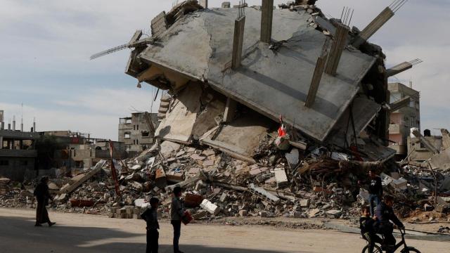 Palestinos pasan junto a los escombros de casas destruidas por el Ejército israelí en Rafah.