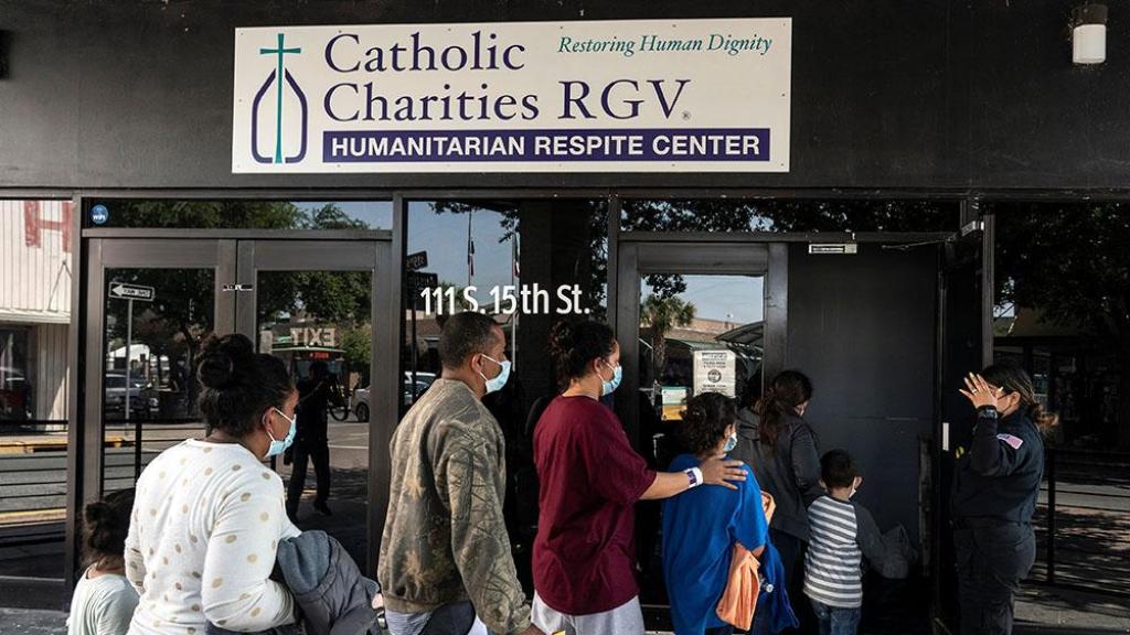 Migrantes que buscan asilo en EEUU ingresan a un centro humanitario temporal gestionado por Caridades Católicas del Valle del Río Grande en McAllen, Texas, el 8 de abril de 2025.