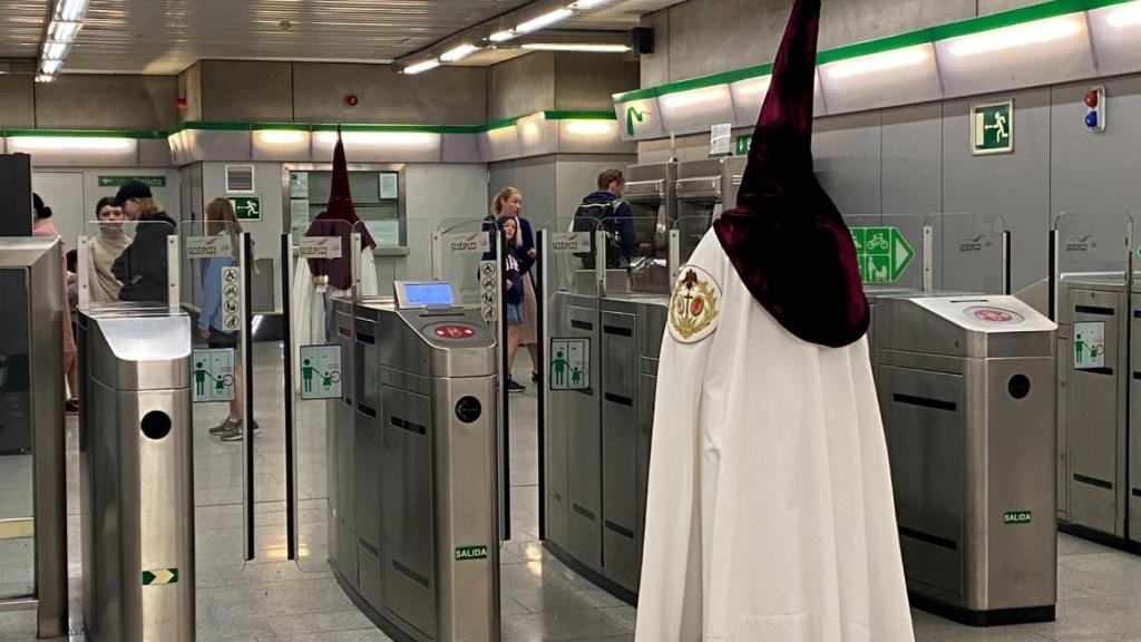 Un nazareno haciendo uso del suburbano sevillano.