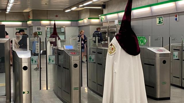 Un nazareno haciendo uso del suburbano sevillano.